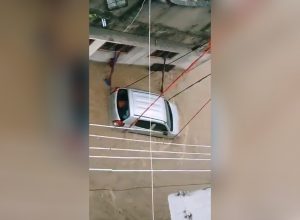 Man ties car with rop to prevent it from getting washed away