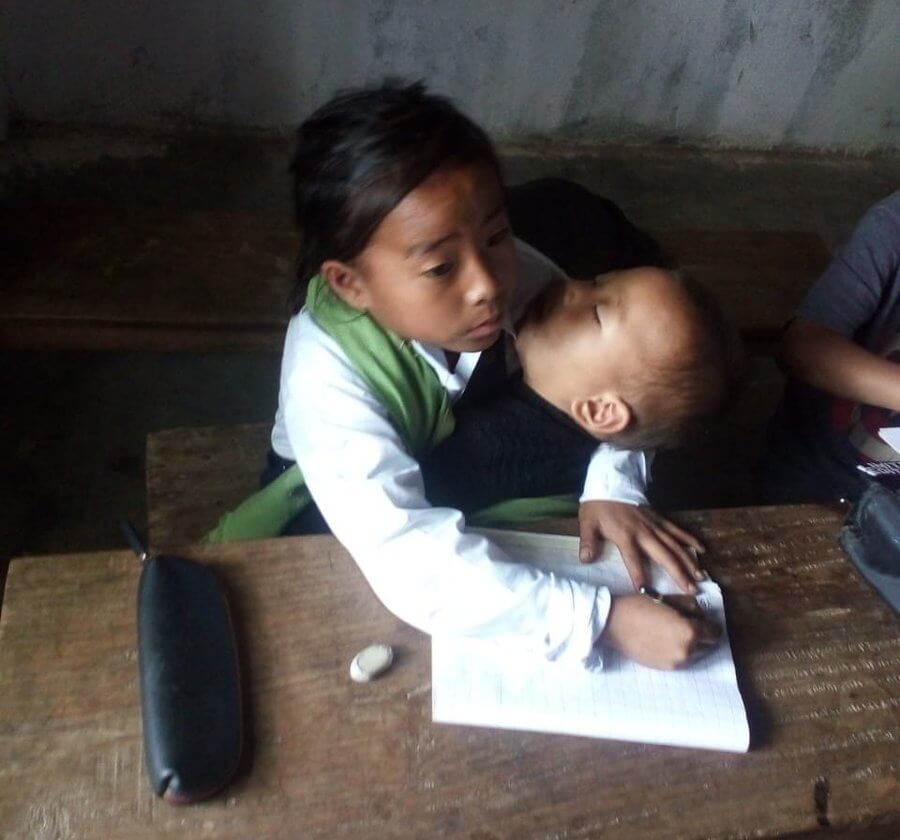 Manipur girl takes her one year old sister in lap to school to study