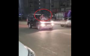 Girl sitting on car bonnet (1)